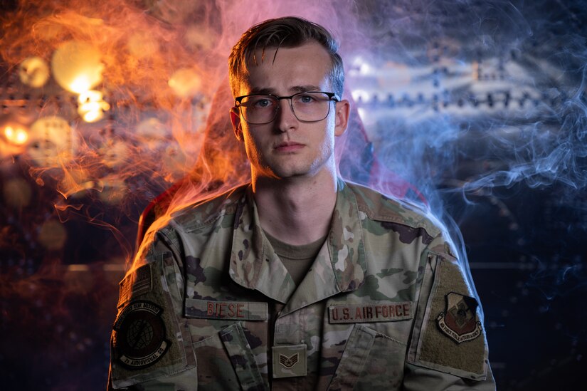 An airman in uniform with a colorful background