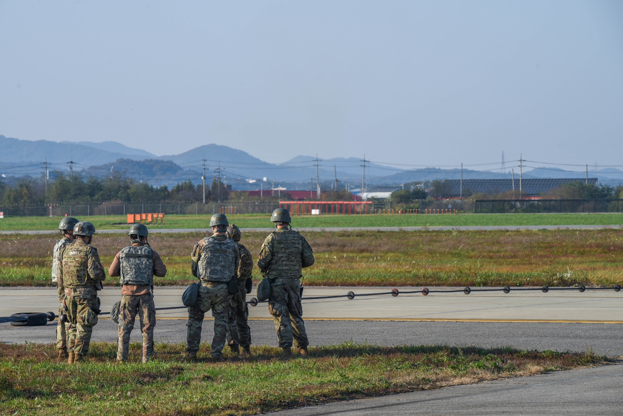 Airmen from the 51st Civil Engineer Squadron view an activated alternate landing strip during Vigilant Defense 24 at Osan Air Base, Republic of Korea, Oct. 29, 2023. The ALS converts a taxiway into a runway, allowing pilots to operate despite damaged runways. This enables pilots to execute the Fight Tonight mission during contingencies. VD24 is a routine training event that tests the military capabilities across the peninsula, allowing combined and joint training at both the operational and tactical levels. (U.S. Air Force photo by Airman 1st Class Chase Verzaal)