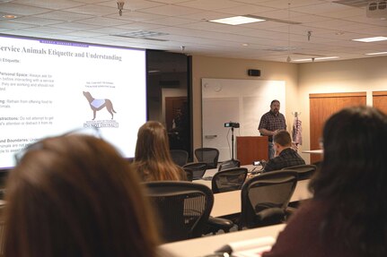 Naval Undersea Warfare Center Division, Keyport Quality Assurance Specialist Bill Longworth addresses the topic of service animal etiquette during the command’s 2023 National Disability Employment Awareness Month observance, Oct. 24.