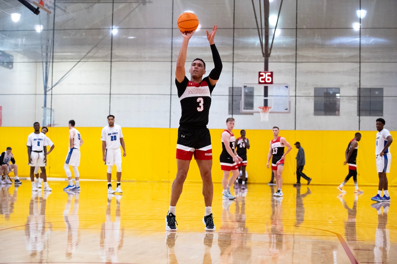 A basketball player shoots a technical foul free throw as other players stand in the background.