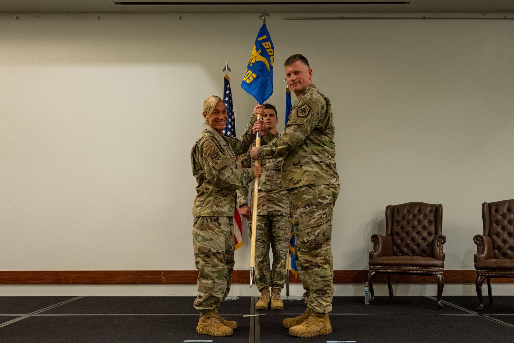 U.S. Air Force Col. Allison Black, 1st Special Operations Wing commander, passes the guide-on to Lt. Col. Weston Higbee, 1st Special Operations Theater Air Operations Squadron commander, at the 1 SOTAOS activation ceremony at Hurlburt Field, Florida, Oct. 18, 2023.