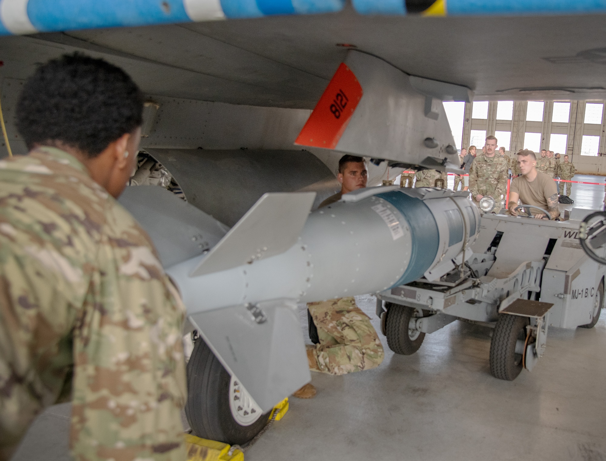 Airman load a weapon to a F-16 Fighting Falcon.