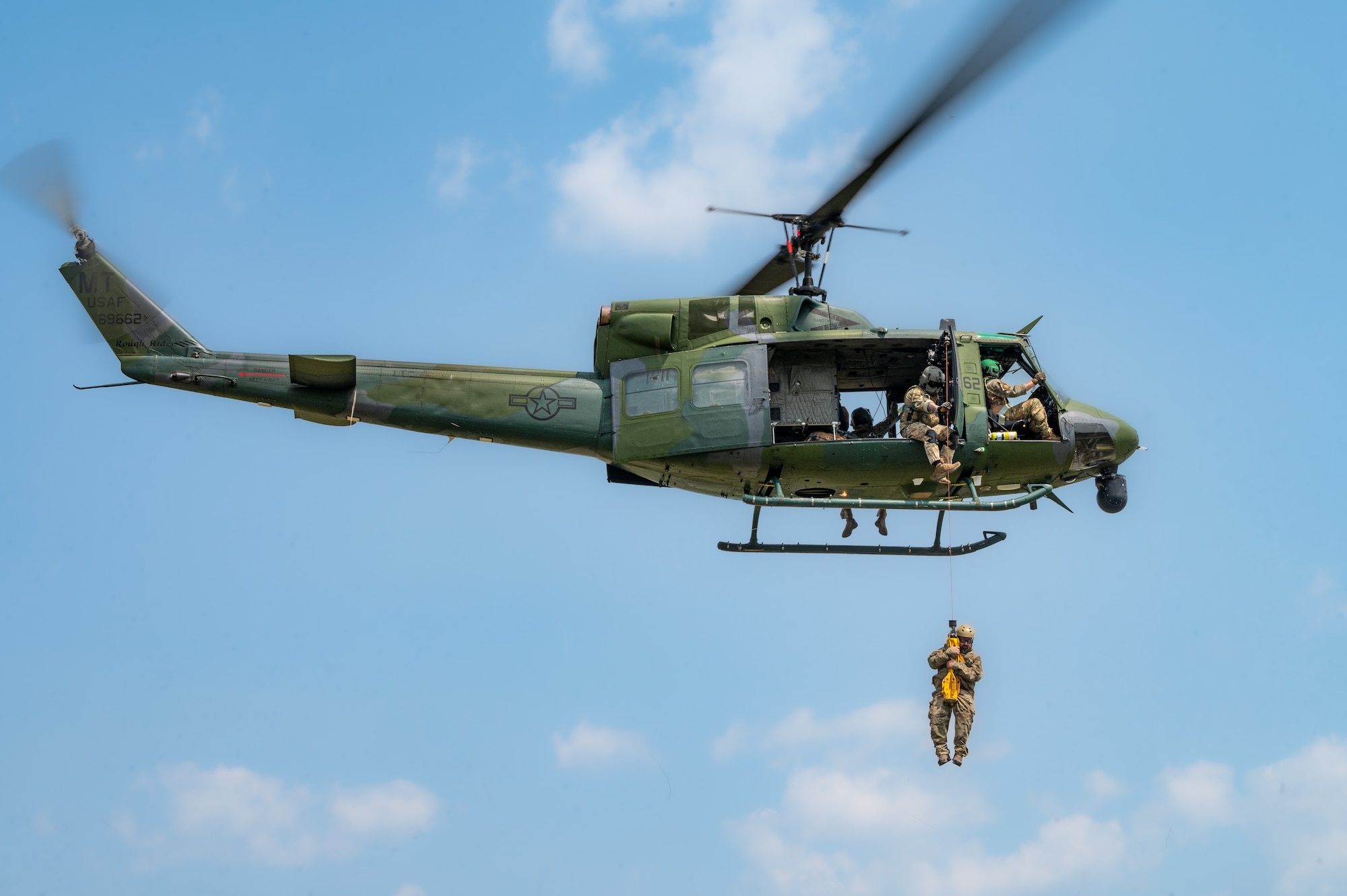 Airmen assigned to the 54th Helicopter Squadron (HS) perform personnel recovery training with aircrew at the Air National Guard training grounds in Garrison, North Dakota, May 24, 2023. The 54th HS provides a rapidly-deployable, combat rescue and reaction force response utilizing UH-1 Huey helicopters. (U.S. Air Force photo by Airman 1st Class Alexander Nottingham)