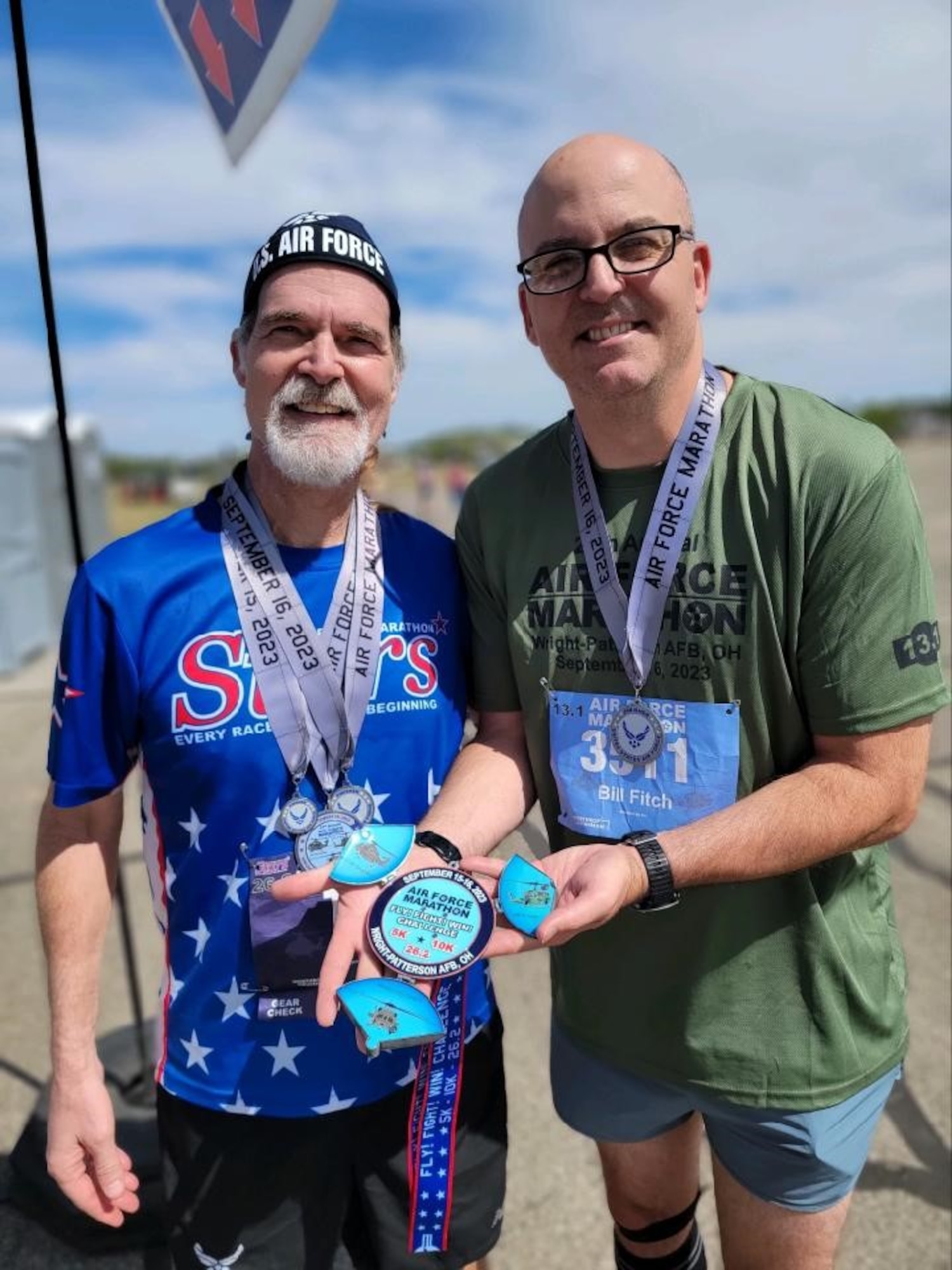 Air Force Life Cycle Management Center Command Chief James Fitch holds an Air Force Marathon medal while posing for a photo with Gary Moroney at the National Museum of the U.S. Air Force on Wright-Patterson Air Force Base, Ohio, Sept. 16, 2023. Moroney has participated in every Air Force Marathon since its inception. (Courtesy Photo)