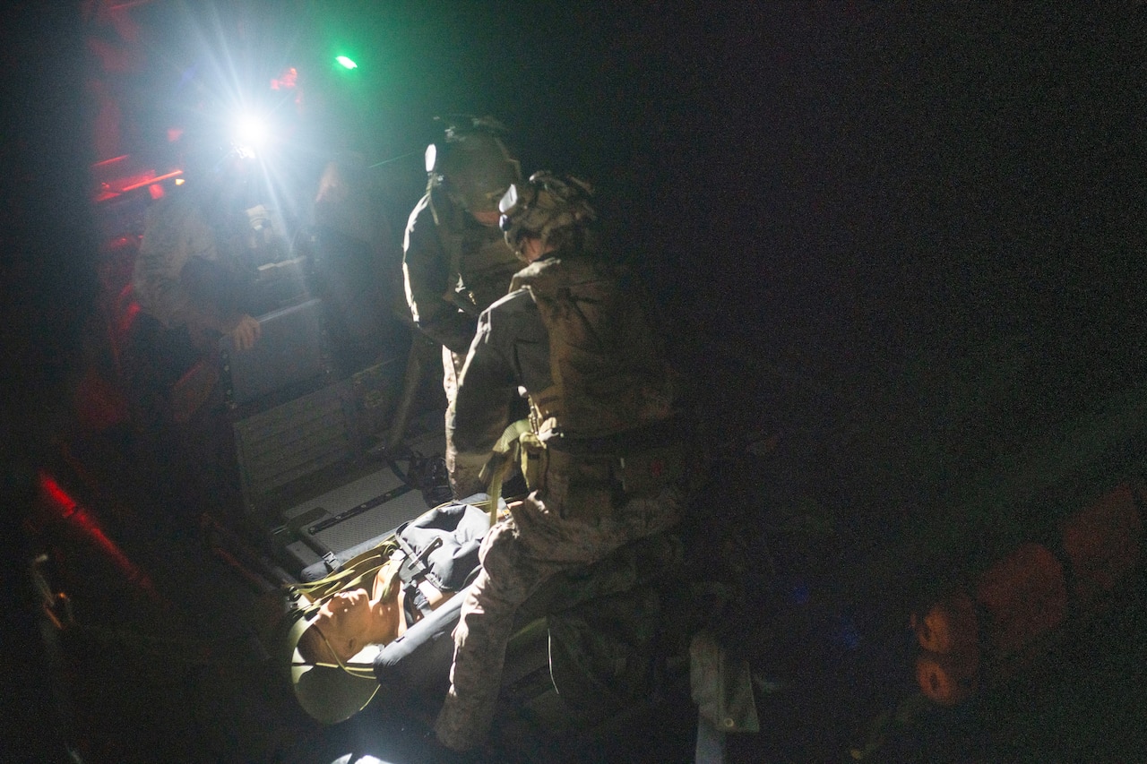 Marines receive a simulated casualty at night.