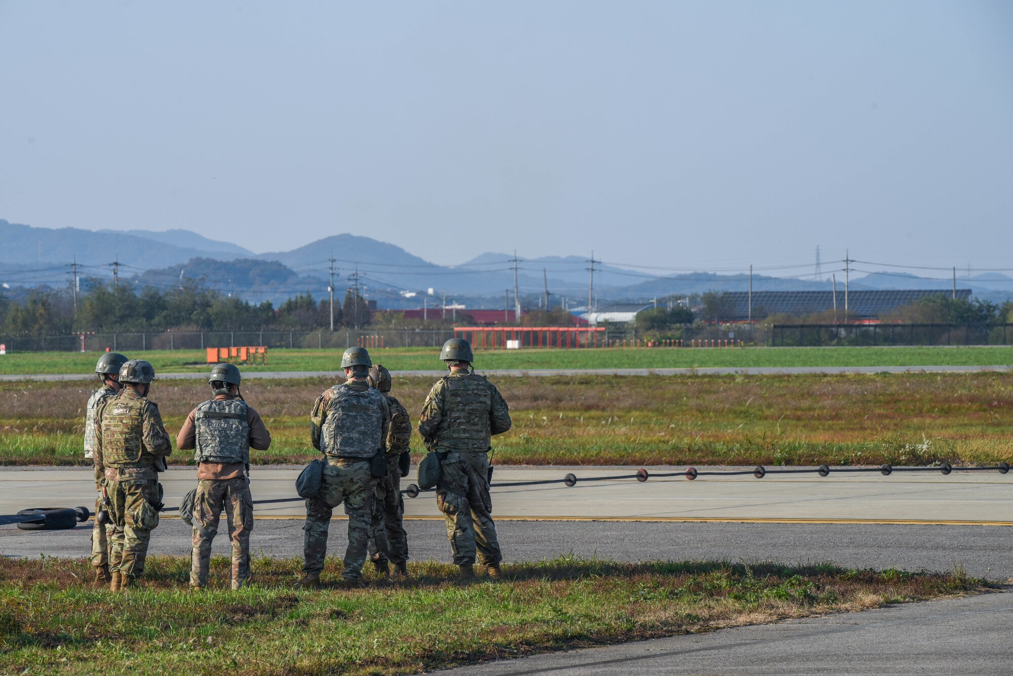 Airmen from the 51st Civil Engineer Squadron view an activated alternate landing strip during Vigilant Defense 24 at Osan Air Base, Republic of Korea, Oct. 29, 2023. The ALS converts a taxiway into a runway, allowing pilots to operate despite damaged runways. This enables pilots to execute the Fight Tonight mission during contingencies. VD24 is a routine training event that tests the military capabilities across the peninsula, allowing combined and joint training at both the operational and tactical levels. (U.S. Air Force photo by Airman 1st Class Chase Verzaal)