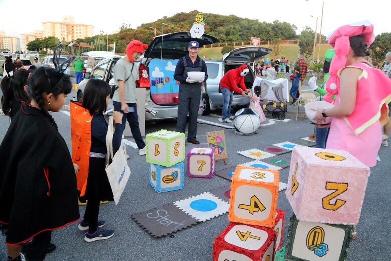 １０月２９日、海兵隊キャンプ・キンザーチャペルの駐車場に地元の小学生たちが招待され、トランク・オア・トリートに参加しました。
小学生たちは毎月キャンプ・キンザーSMPの地域交流イベントで交流のある児童センターの子供たちです。子供たちはチャペルのボランティアたちが準備した夕食を食べ、基地の子供たちと一緒にお菓子を貰いました。