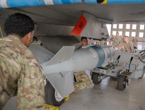 Airman load a weapon to a F-16 Fighting Falcon.