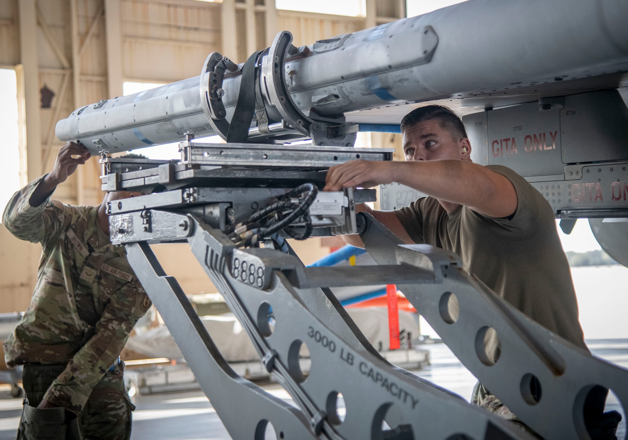 Airmen work together on an F-16 Fighting Falcon during a weapons load competition.