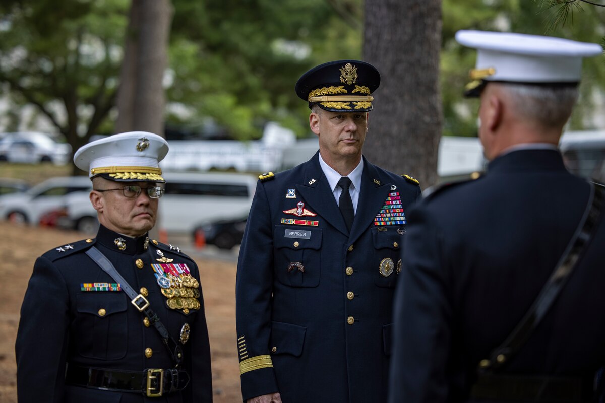 Men in dress uniform stand together outdoors.
