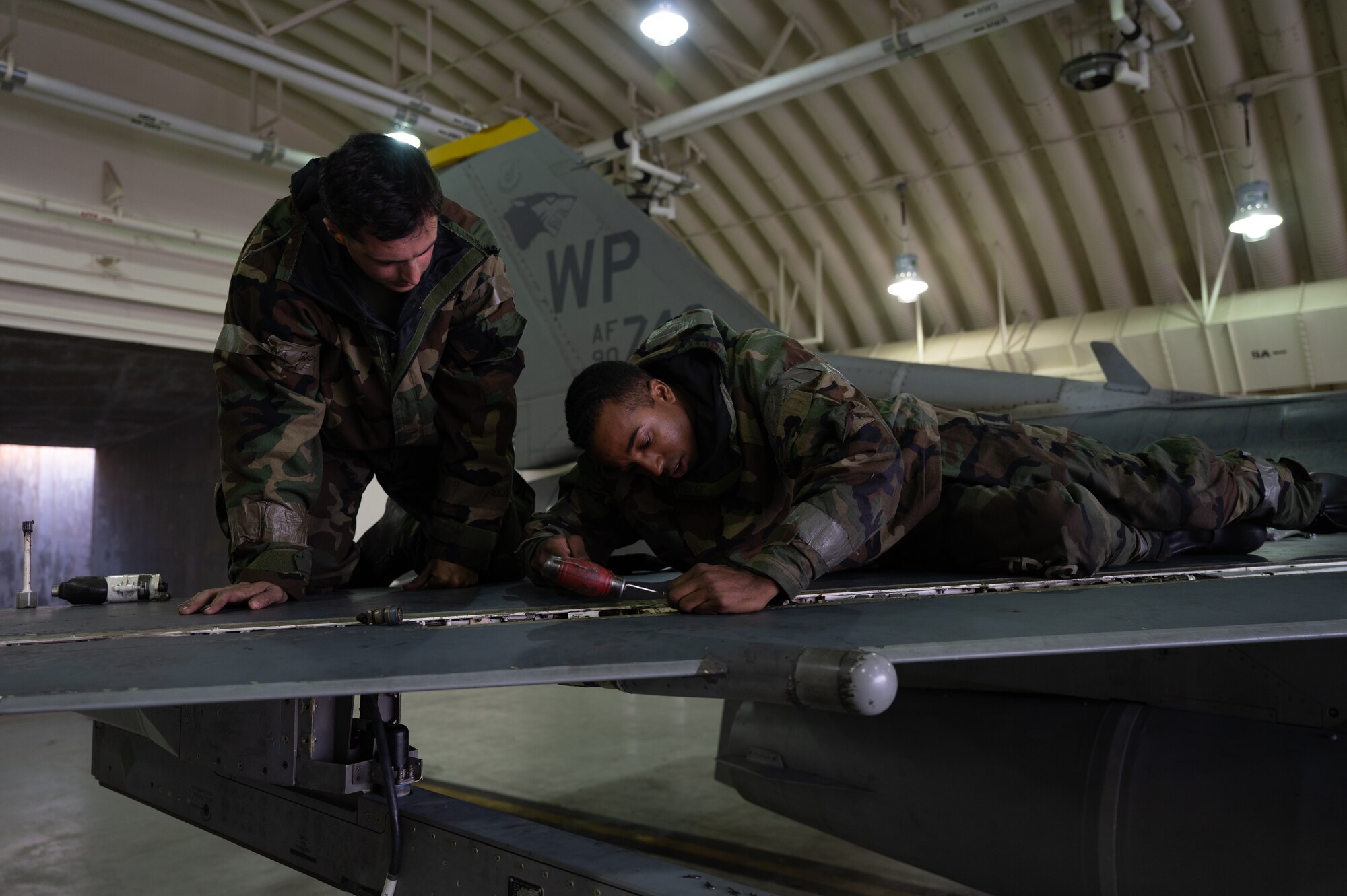 Senior Airman Wade Brosz and Staff Sgt. Zion Littlejohn conduct repairs on the wing of a U.S. Air Force F-16 Fighting Falcon during Vigilant Defense 24.