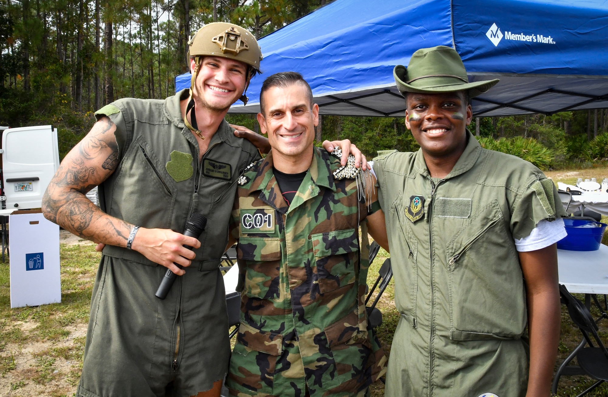 Three individuals pose for a photo, dressed in old military uniforms.