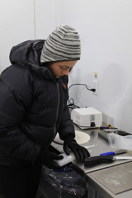 An ice researcher at the U.S. Army Engineer Research and Development Center’s Cold Regions Research and Engineering Laboratory prepares thin sections from an ice block made with additives to increase strength and melt resistance of ice. The research is performed in a cold environmental chamber within the laboratory’s Cold Room Complex. (U.S. Army Corps of Engineers photo by Joseph Bara)