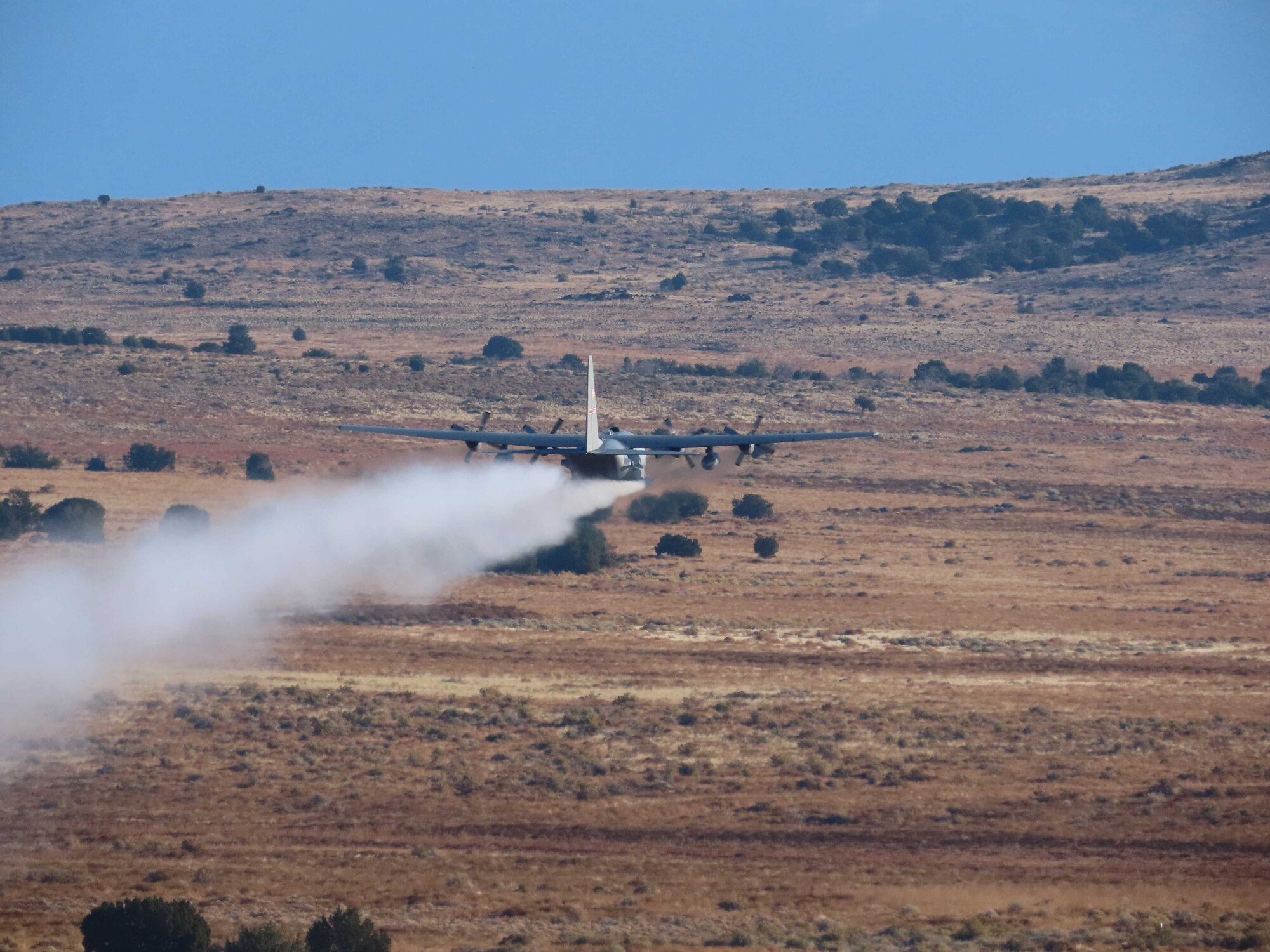 A C-130H Hercules aircraft from Youngstown Air Reserve Station, Ohio, applies herbicide to the Utah Test and Training Range, Hill Air Force Base,  to create fire breaks for wildfire prevention and safe unexploded ordnance removal, Oct. 28, 2023.