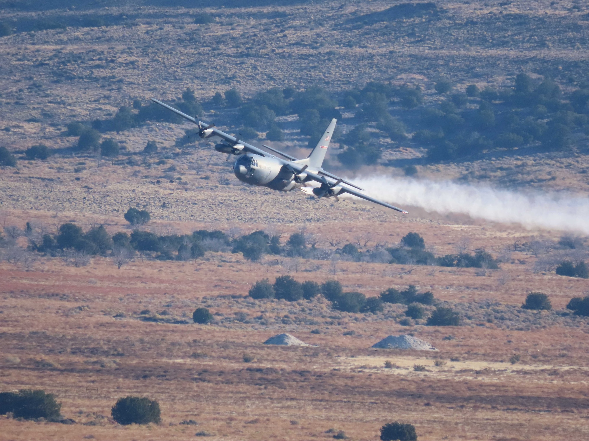 A C-130H Hercules aircraft from Youngstown Air Reserve Station, Ohio, applies herbicide to the Utah Test and Training Range, Hill Air Force Base,  to create fire breaks for wildfire prevention and safe unexploded ordnance removal, Oct. 28, 2023.