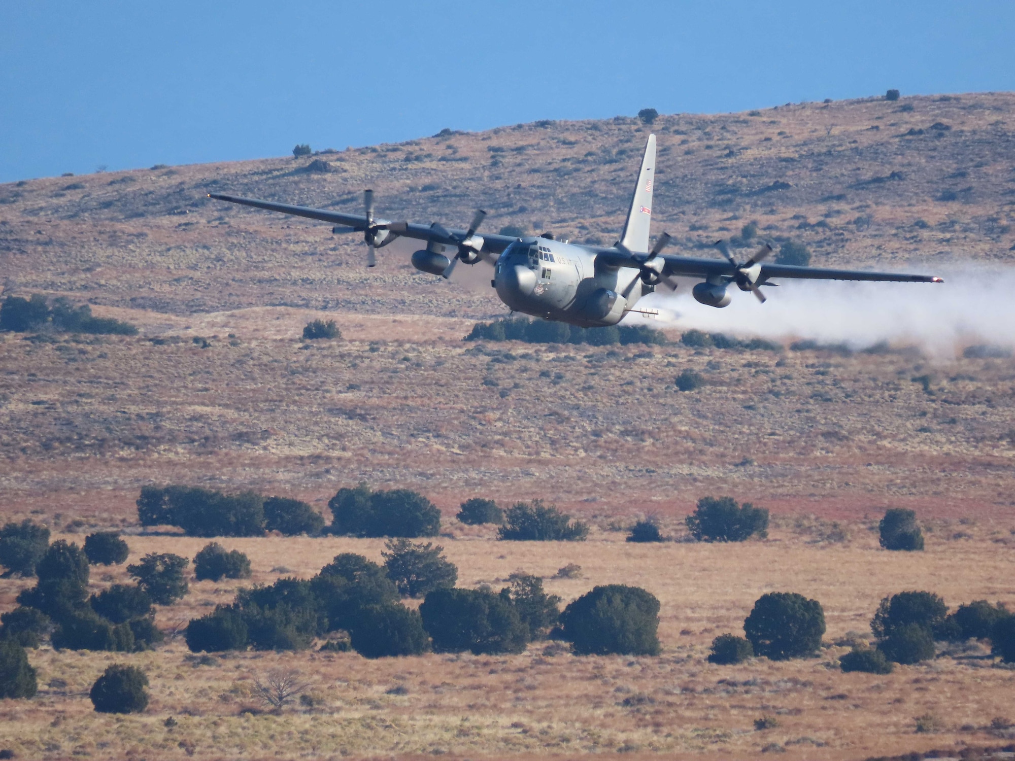 A C-130H Hercules aircraft from Youngstown Air Reserve Station, Ohio, applies herbicide to the Utah Test and Training Range, Hill Air Force Base,  to create fire breaks for wildfire prevention and safe unexploded ordnance removal, Oct. 28, 2023.