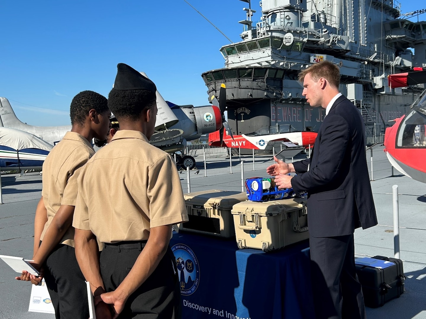 Naval Research Laboratory Project Lead, Kevin Cronin, answers questions from Junior ROTC cadets regarding the Hydrogen-Small Unit Power Ruggedized Expeditionary Power Source aboard the USS Intrepid Sea, Air and Space Museum as part of Navy’s kickoff event for Climate Week NYC, Sept. 17, 2023.