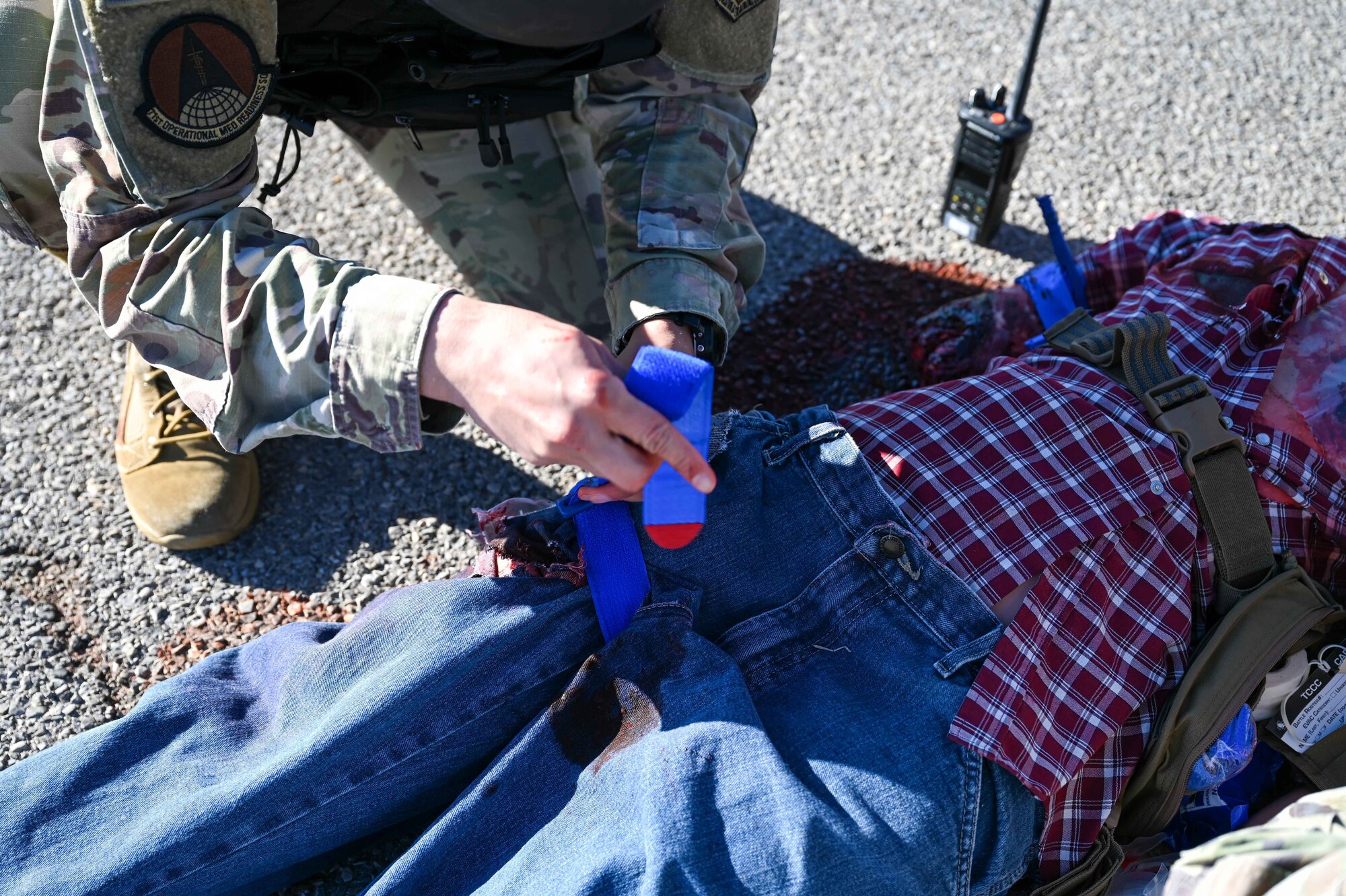 U.S. Air Force Tech. Sgt. Robert Thorne, 71st Medical Group diagnostic and therapeutics flight chief, places a tourniquet on a mannequin during the Caduceus Spear exercise at Clinton Sherman Airfield Park, Oklahoma, Oct. 26, 2023. The intent of the exercise was to identify training gaps in the comprehensive medical readiness of the Airmen. (U.S. Air Force photo by Airman 1st Class Kari Degraffenreed)