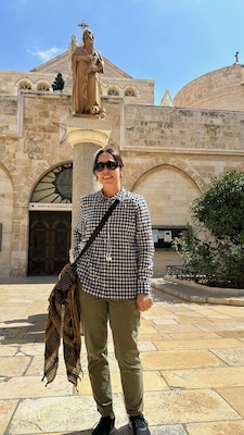 Woman stands in front of stone building
