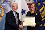 Photo is of a man and woman standing and holding a certificate between them