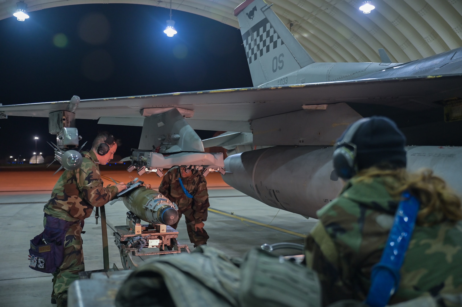 Staff Sgt. Ashton Alamo reads the technical order before securing a munition to a U.S. Air Force F-16 Fighting Falcon during Vigilant Defense 24.