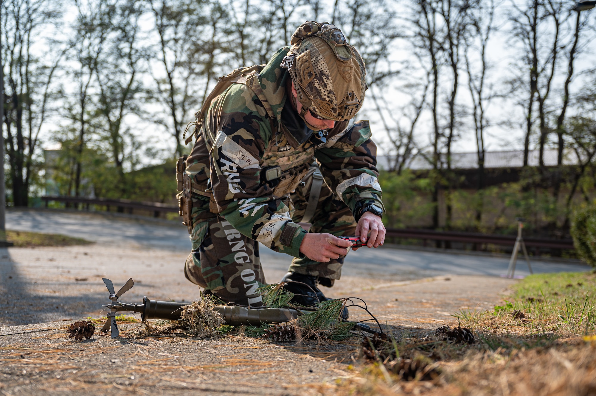 U.S. Air Force Staff Sgt. Carson Hudson, 51st Civil Engineer Squadron Explosive Ordnance Disposal team leader, takes a photo of a simulated unexploded ordnance during Vigilant Defense 24 at Osan Air Base, Republic of Korea, Oct. 31, 2023. VD24 is a routine training event that tests the military capabilities across the peninsula, allowing combined and joint training at both the operational and tactical levels. The 51st Fighter Wing guards the freedom of 51 million people by deterring aggression, defending the ROK, and defeating any attack against the ironclad ROK-US Alliance. (U.S. Air Force photo by Staff Sgt. Thomas Sjoberg)