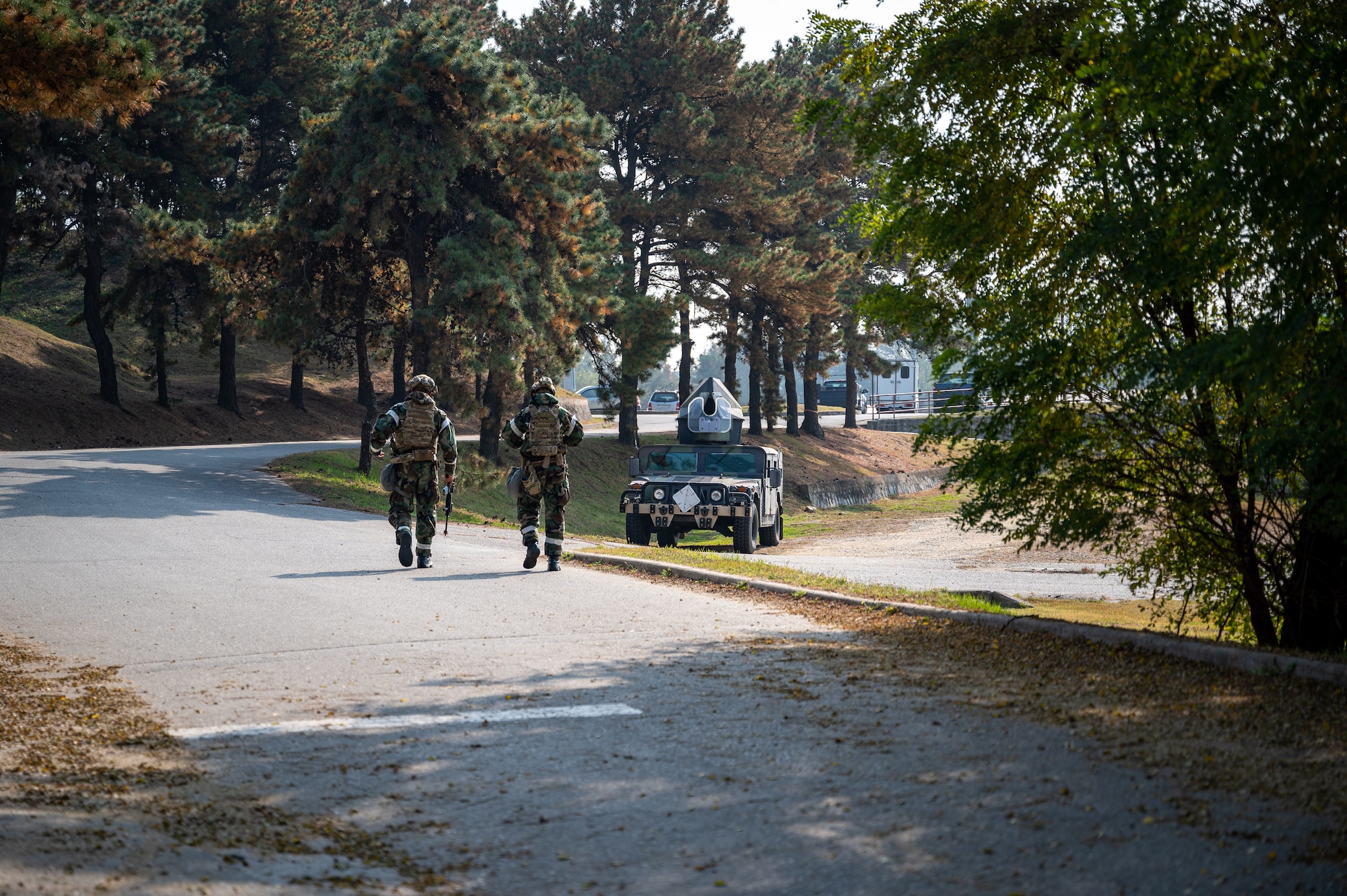 U.S. Air Force Senior Airman Noah Yates, left, 51st Civil Engineer Squadron Explosive Ordnance Disposal technician, and Staff Sgt. Carson Hudson, 51st CES EOD team leader, walk to their Humvee after preparing a simulated unexploded ordnance to be disposed of during the Vigilant Defense 24 training event at Osan Air Base, Republic of Korea, Oct. 31, 2023. VD24 is a routine training event that tests the military capabilities across the peninsula, allowing combined and joint training at both the operational and tactical levels. (U.S. Air Force photo by Staff Sgt. Thomas Sjoberg)
