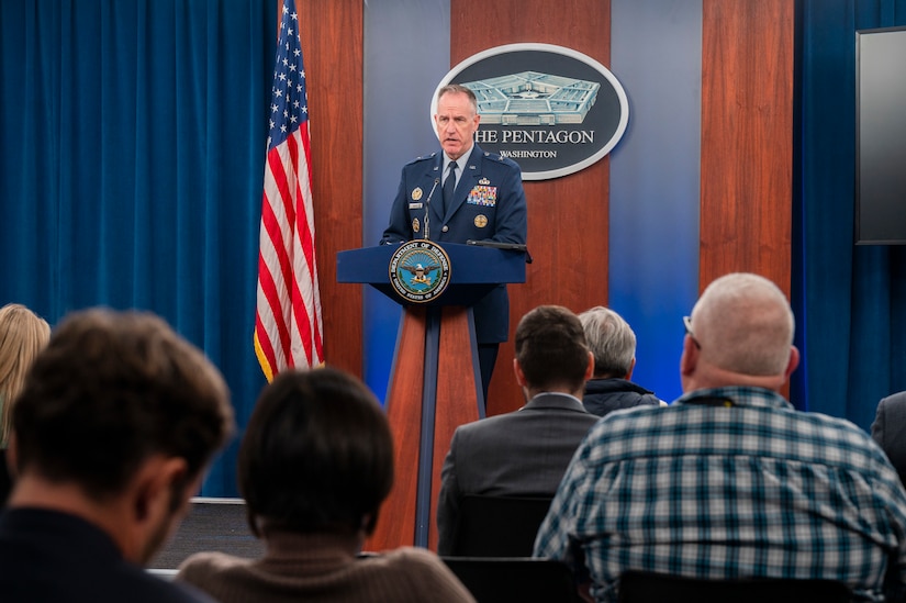 A man speaks from a podium to an audience.