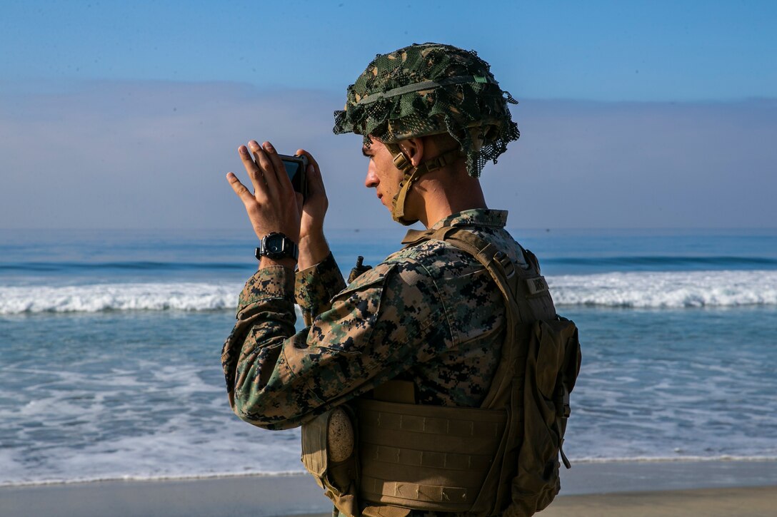 U.S. Marine Corps Lance Cpl. Joseph Burns, a combat engineer with the Littoral Engineer Reconnaissance Team, 9th Engineer Support Battalion, 3d Marine Logistics Group, utilizes the Android Tactical Assault System while conducting a reconnaissance patrol during a littoral mobility and detection exercise on Camp Pendleton, California, Nov. 18, 2021. The ATAK is a tool that allows Marines to rapidly report critical geospatial information to support intelligence requirements for a given objective. During this exercise, 7th and 9th ESB are refining their skills with emerging Marine Corps technologies in order to facilitate follow-on forces’ littoral mobility from shallow water to the objective. (U.S. Marine Corps photo by Sgt. Hailey D. Clay)