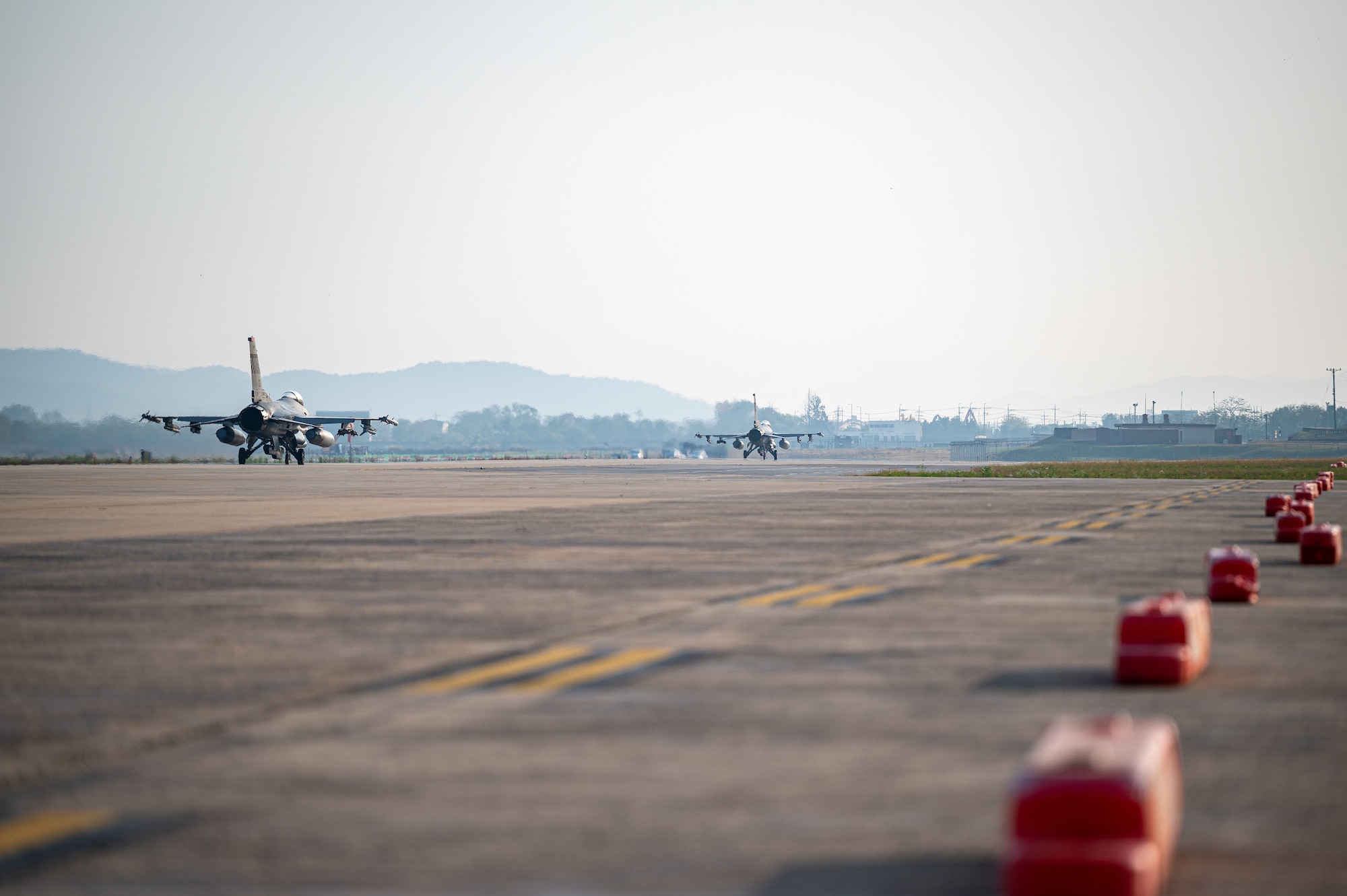 U.S. Air Force F-16 Fighting Falcons taxi down an alternate landing strip during Vigilant Defense 24 at Osan Air Base, Republic of Korea, Oct. 30, 2023. The taxiway on the flightline becomes an active air strip when the ALS is activated. VD24 is a routine training event that tests the military capabilities across the peninsula, allowing combined and joint training at both the operational and tactical levels. (U.S. Air Force photo by Staff Sgt. Thomas Sjoberg)