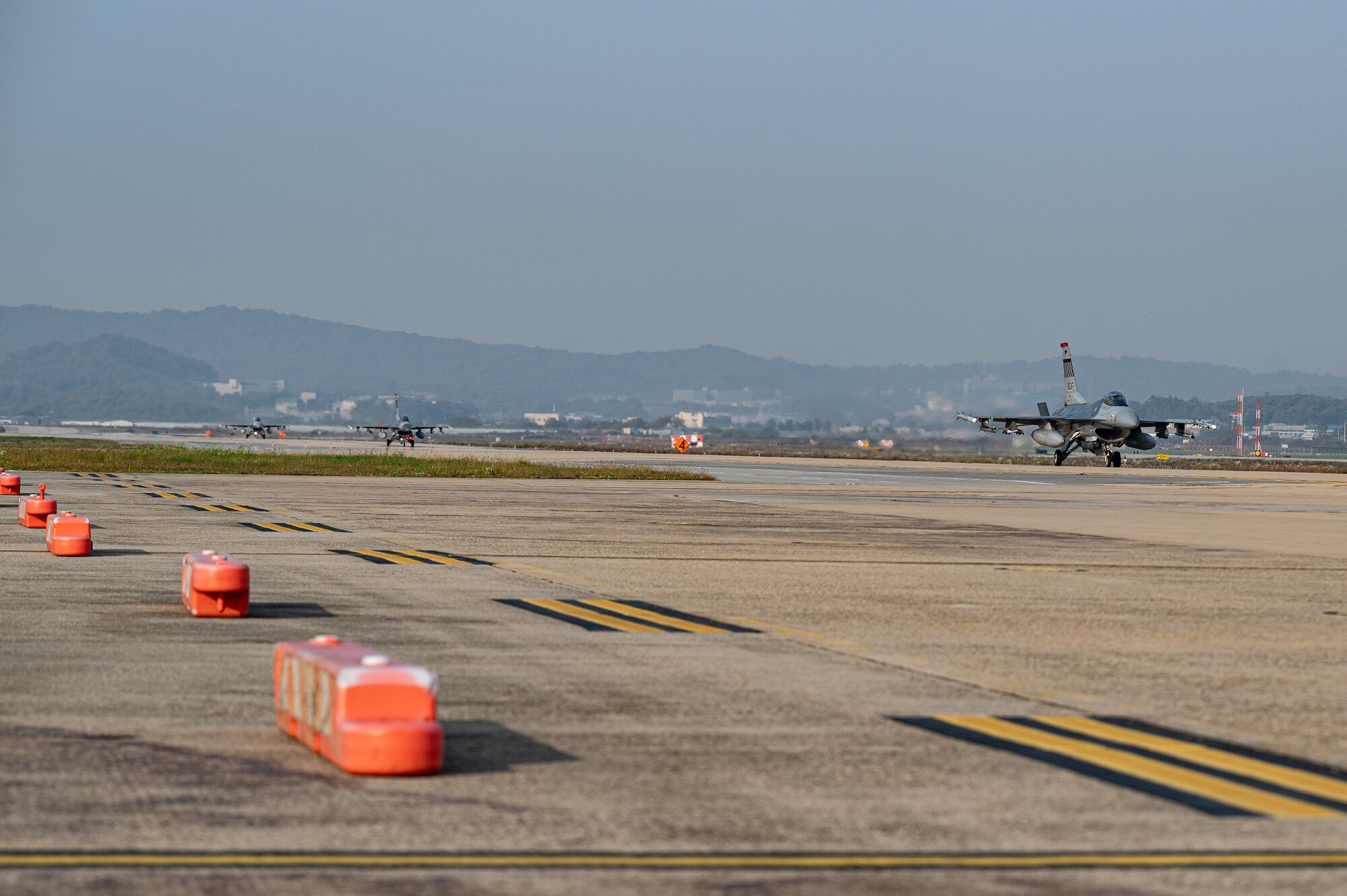 U.S. Air Force F-16 Fighting Falcons taxi down an alternate landing strip during Vigilant Defense 24 at Osan Air Base, Republic of Korea, Oct. 30, 2023. In contingency environments, the ALS is activated when the main runway sustains heavy damage, which allows pilots to maintain readiness and continue flying operations. VD24 is a routine training event that tests the military capabilities across the peninsula, allowing combined and joint training at both the operational and tactical levels. (U.S. Air Force photo by Staff Sgt. Thomas Sjoberg)