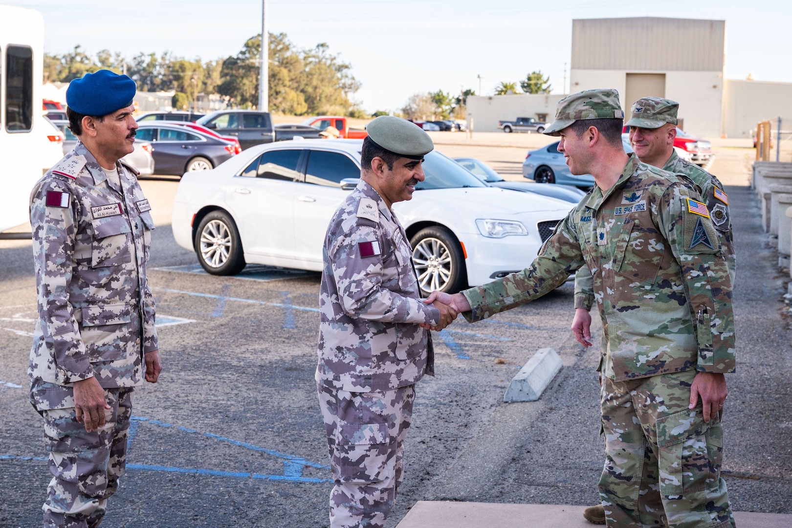 A Qatari Armed Forces General Shakes hands with a U.S. Space Force Lieutenant Colonel outside a building.