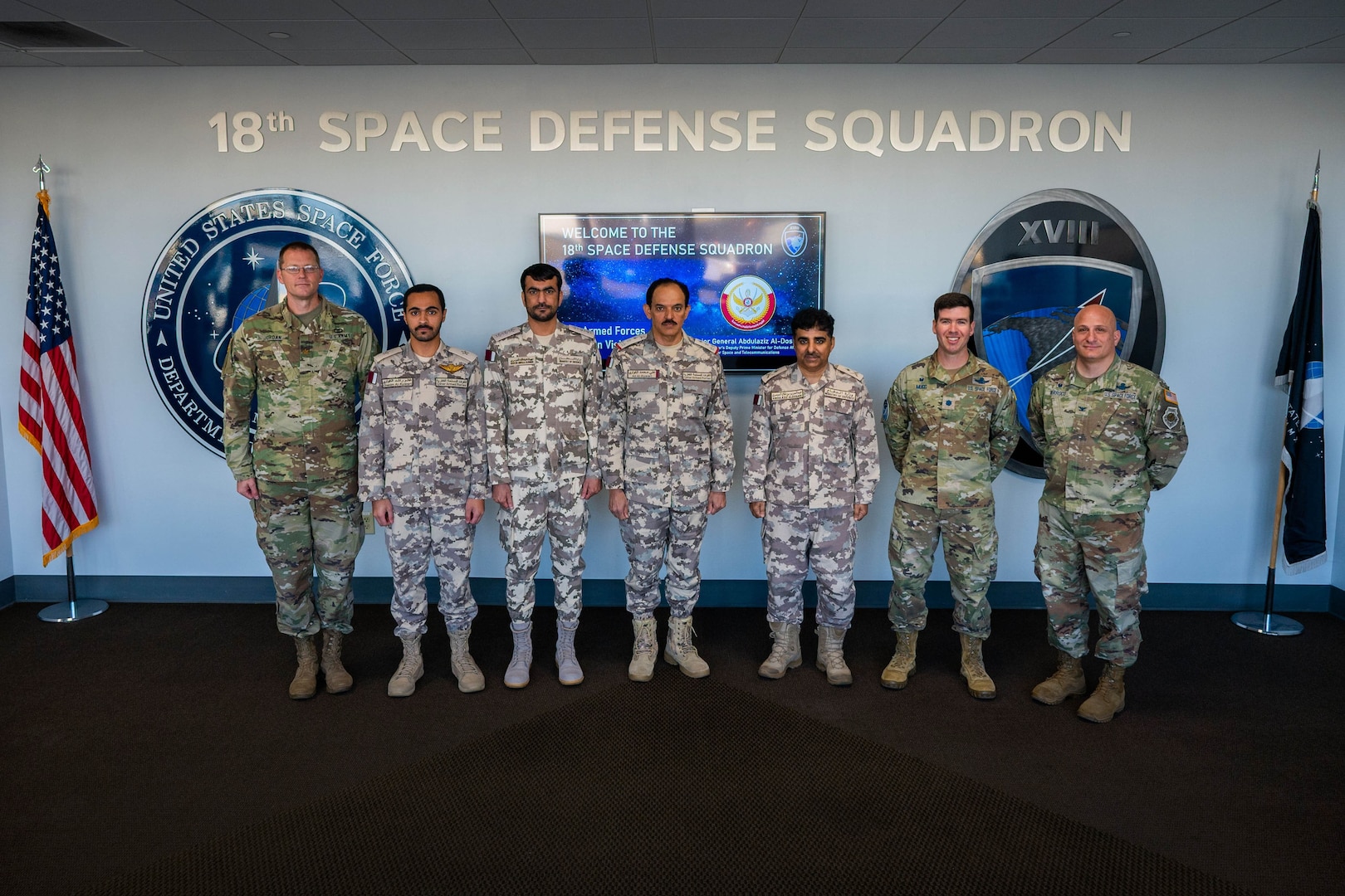 U.S. military member and Qatari Armed Forces members stand together for a group photo.