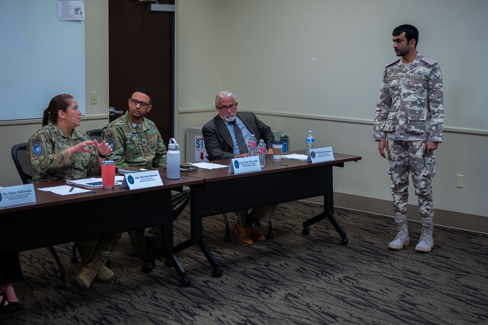 A member of the 18th Space Defense Squadron asks a question to a Qatari Armed Forces member.