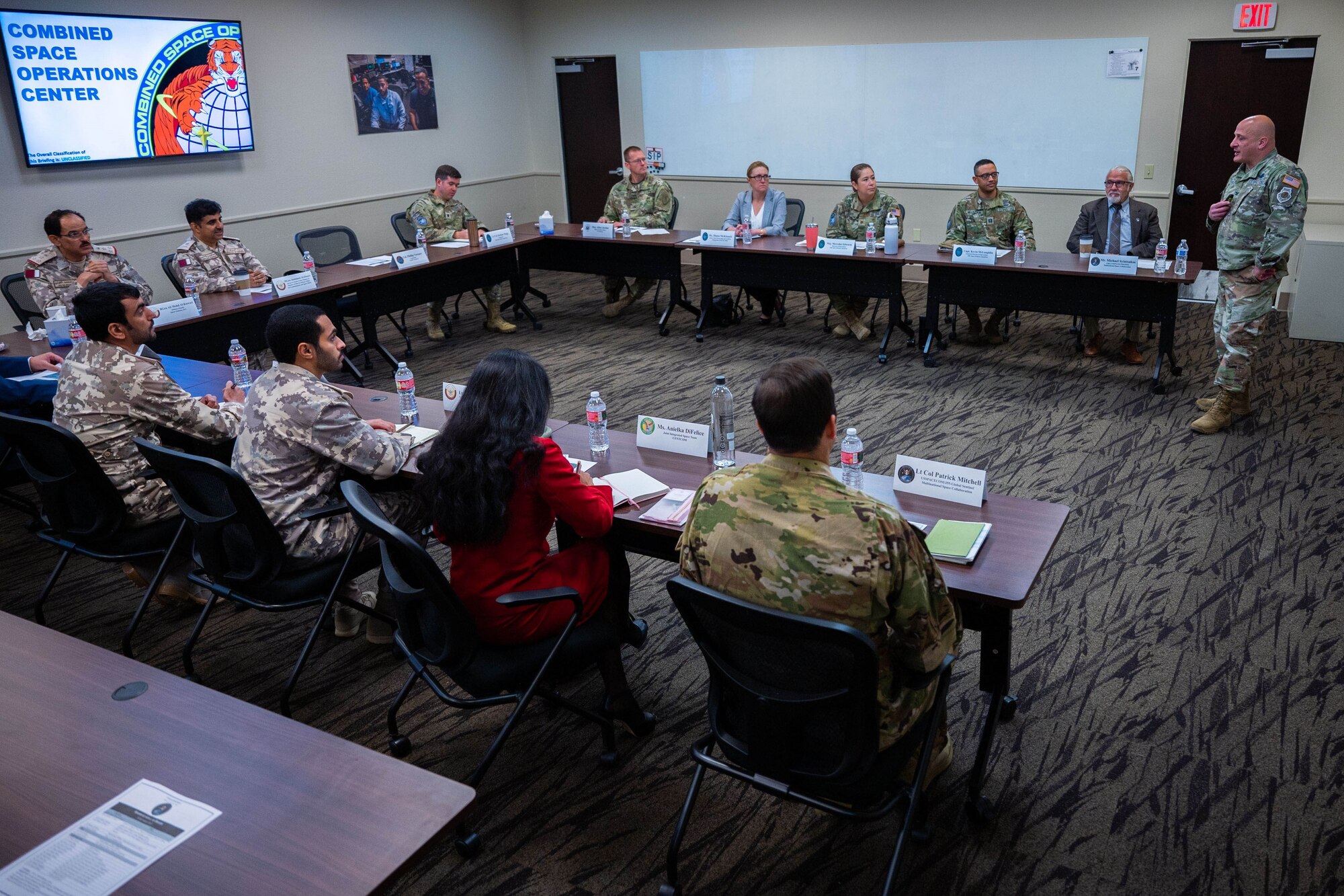 A U.S. Space Force Colonel briefs the Combined Space Operations Center mission to a room full of people.