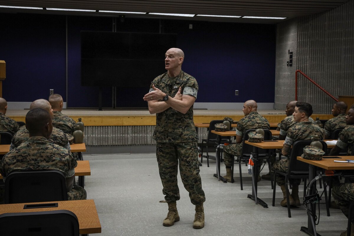 A man in a uniform addresses a classroom.