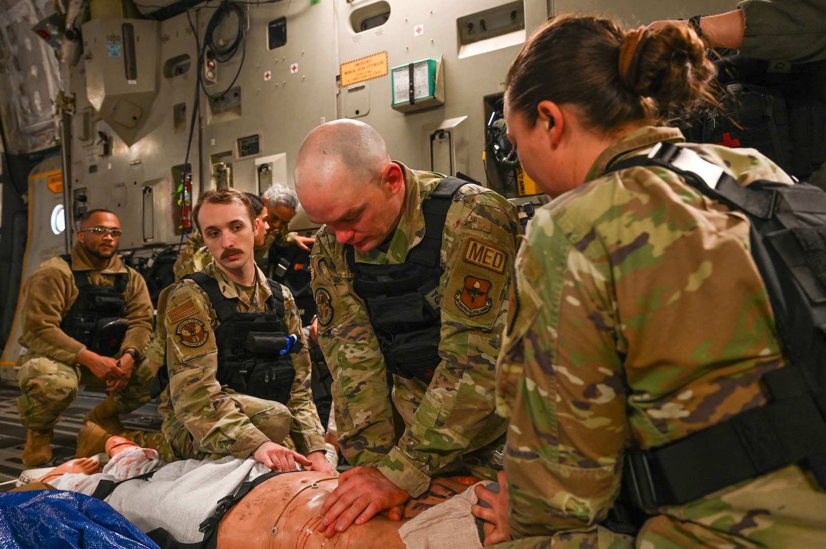 U.S. Air Force Technical Sgt. Robert Throne, 71st Medical Group (MDG) diagnostic and therapeutics flight chief, and Staff Sgt. Rebekah Clifford, 82nd MDG independent duty medical technician, perform first aid on a mannequin during the Caduceus Spear exercise on a C-17 Globemaster III from Altus Air Force Base, Oklahoma, Oct. 26, 2023. The team was tasked with giving life-saving medical care to patients throughout the flight from Clinton Sherman Airfield Park to the 97th Medical Group at Altus Air Force Base. (U.S. Air Force photo by Airman 1st Class Kari Degraffenreed)