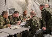 Allied officers serving with the Polish Land Forces’ 2nd Corps brief V Corps Col. Sherman Watson, chief of operational fires, during a command post exercise conducted at Grafenwöhr, Germany, Oct. 26, 2023. V Corps, America’s forward deployed corps, completed its third command post exercise – dubbed “CPX3” – in early November as part of a series of exercises designed to prepare the corps for real-world missions and contingencies. (U.S. Army photo by Spc. Devin Klecan)