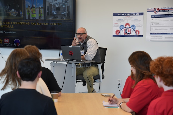 Chad House, a Huntsville Center engineer, sits behind a desk whill speaking to students at Alabama School of Cyber Technology and Engineering Oct. 27. The Huntsville-located charter school is ranked academically in the top 1% of U.S. high schools and is the nation’s only high school focused on the integration of cyber technology and engineering into all academic disciplines.