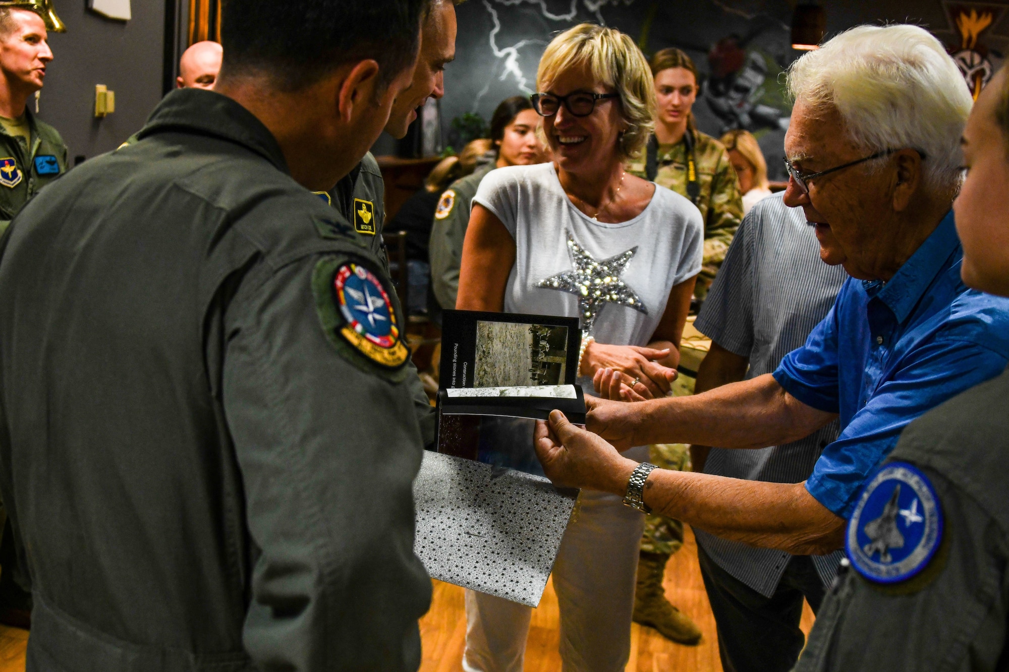 Col. Brad Orgeron, 80th Flying Training Wing commander, receives a photo book of Ankang Airfield from the grandfather of a Norwegian pilot graduate at the Euro-NATO Joint Jet Pilot Training (ENJJPT) program. (Courtesy Photo)
