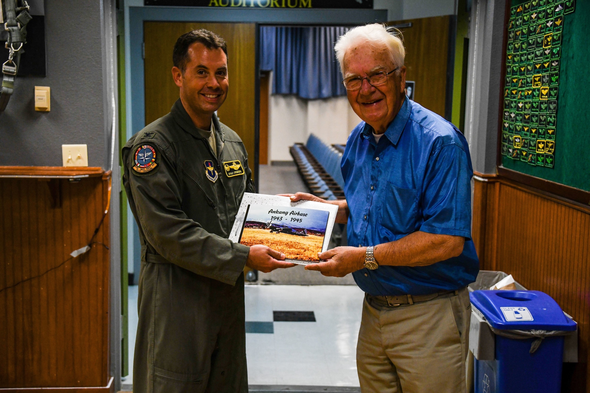 Air Force commander holds photo book with Norwegian man.