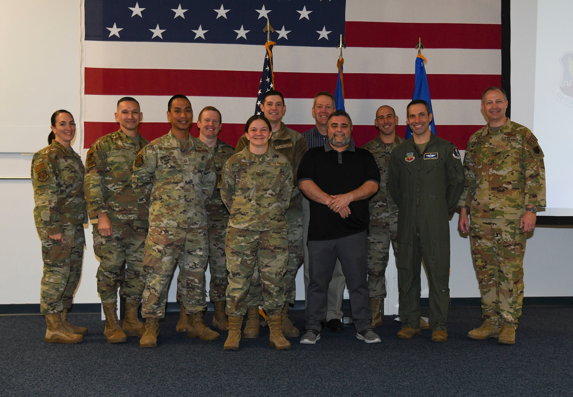 Airmen in green military uniforms pose for a photo.