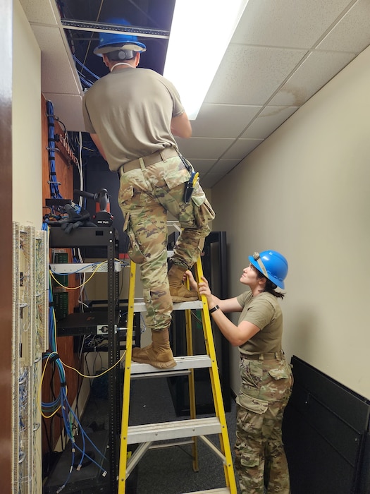 U.S. Air Force Staff Sgt. Jessica Salazar, 85th Engineering Installation Squadron installation technician, installs a cable tray housing fiber optic cable in a facility at Tyndall Air Force Base