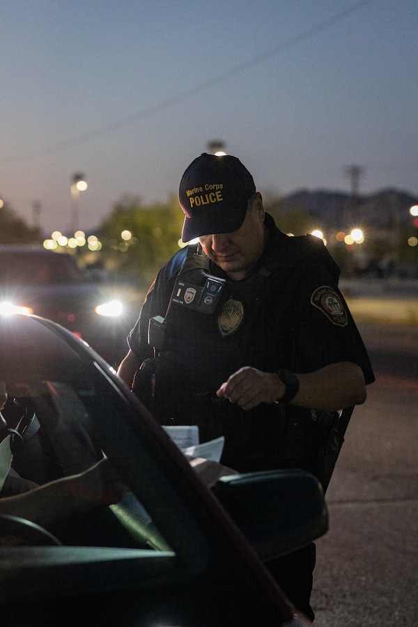 Lieutenant Mark Garcia, a Chino, California native, watch commander with the Provost Marshal’s Office, Headquarters Battalion, Marine Corps Air-Ground Combat Center, gathers insurance and registration information during a traffic stop at MCAGCC, Twentynine Palms, California, Oct. 23, 2023. Military police are responsible for ensuring the safety and security of The Combat Center while conducting law enforcement operations across the base. (U.S. Marine Corps photo by Cpl. Breanna Eason)