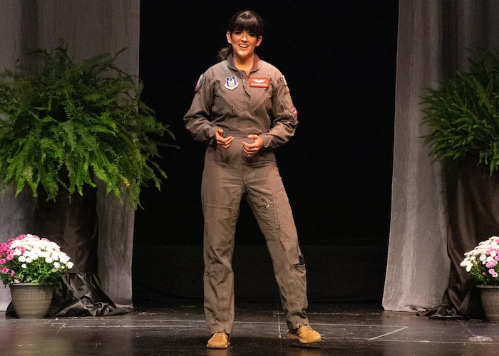 Beightol, in her flight suit, speaks on stage.