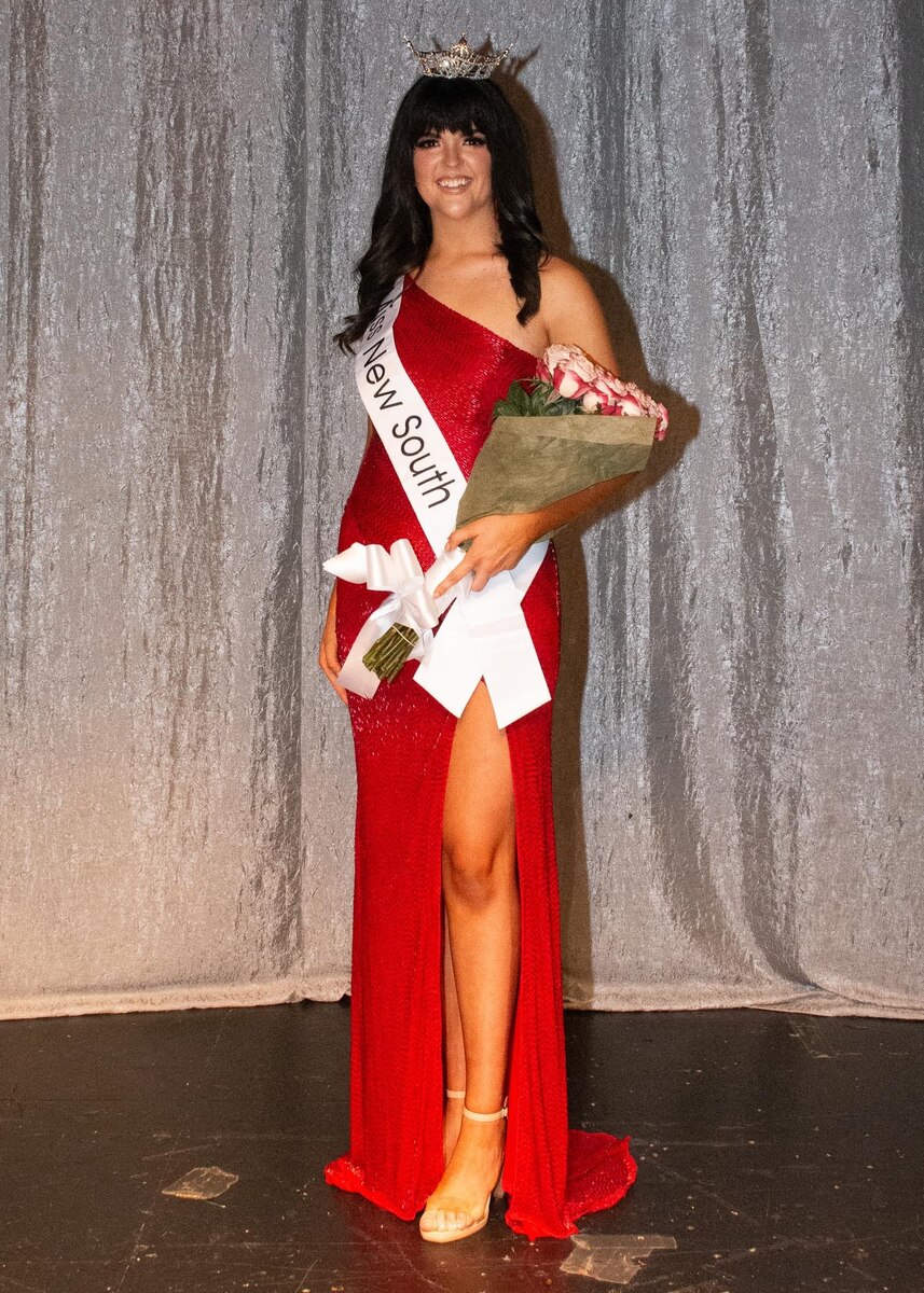 Beightol, in an evening gown, holds a bouquet of flowers