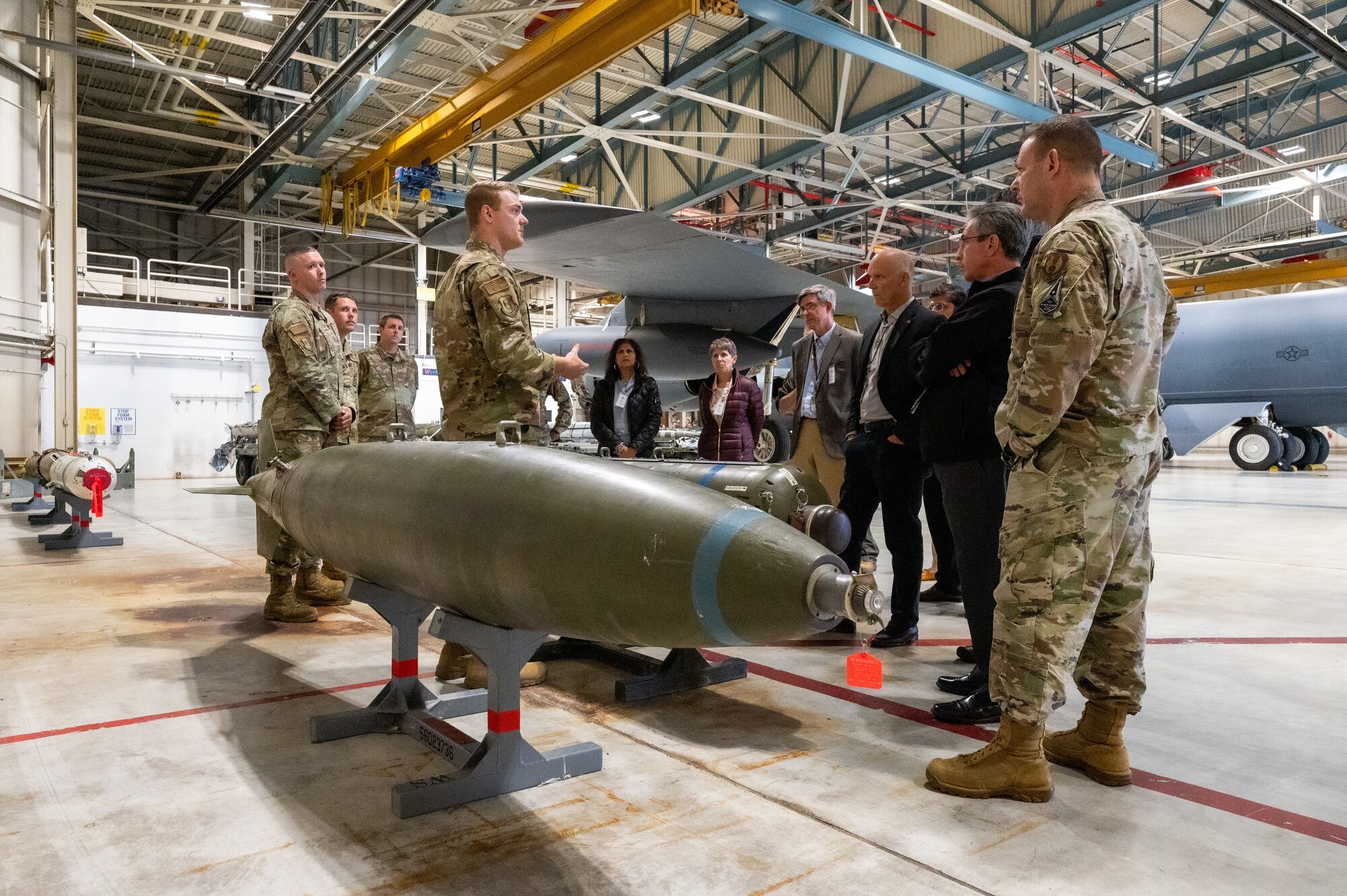 Directors and leaders representing national laboratories from across the U.S. interact with munitions maintenance Airmen near inert training munitions at Minot Air Force Base during a tour of Air Force Global Strike Command installations, October 18, 2023. Gen. Thomas Bussiere, commander of AFGSC, invited the directors for an immersion in the weapons systems and mission of the command while also getting to interact with the Airmen who operate two-thirds of the nuclear enterprise. As critically important partners of AFGSC, the laboratories develop technologies crucial to the U.S. and its future forces. (U.S. Air Force photo by Capt. Joshua Thompson)