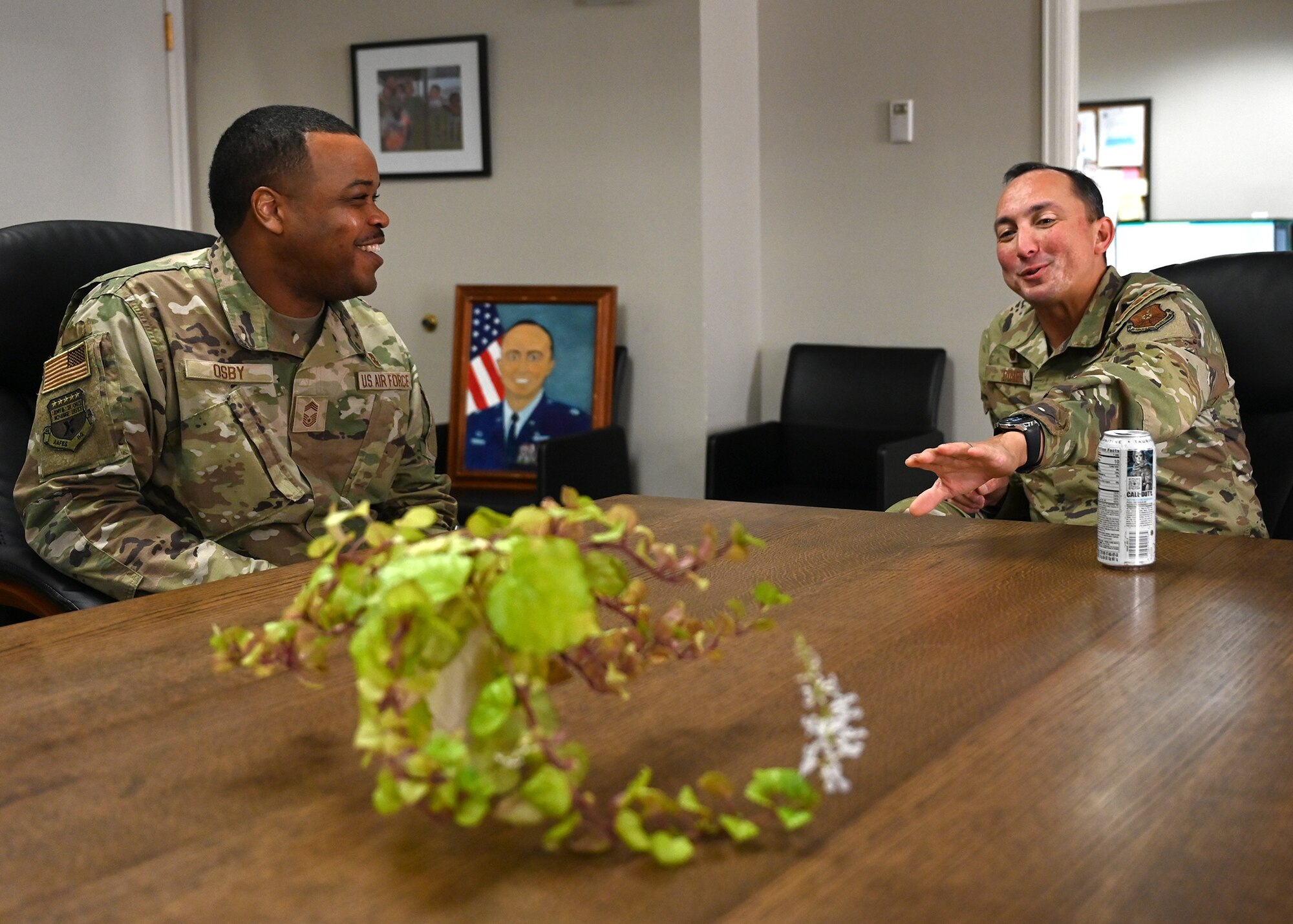 two men sitting at a table, smiling and in discussion