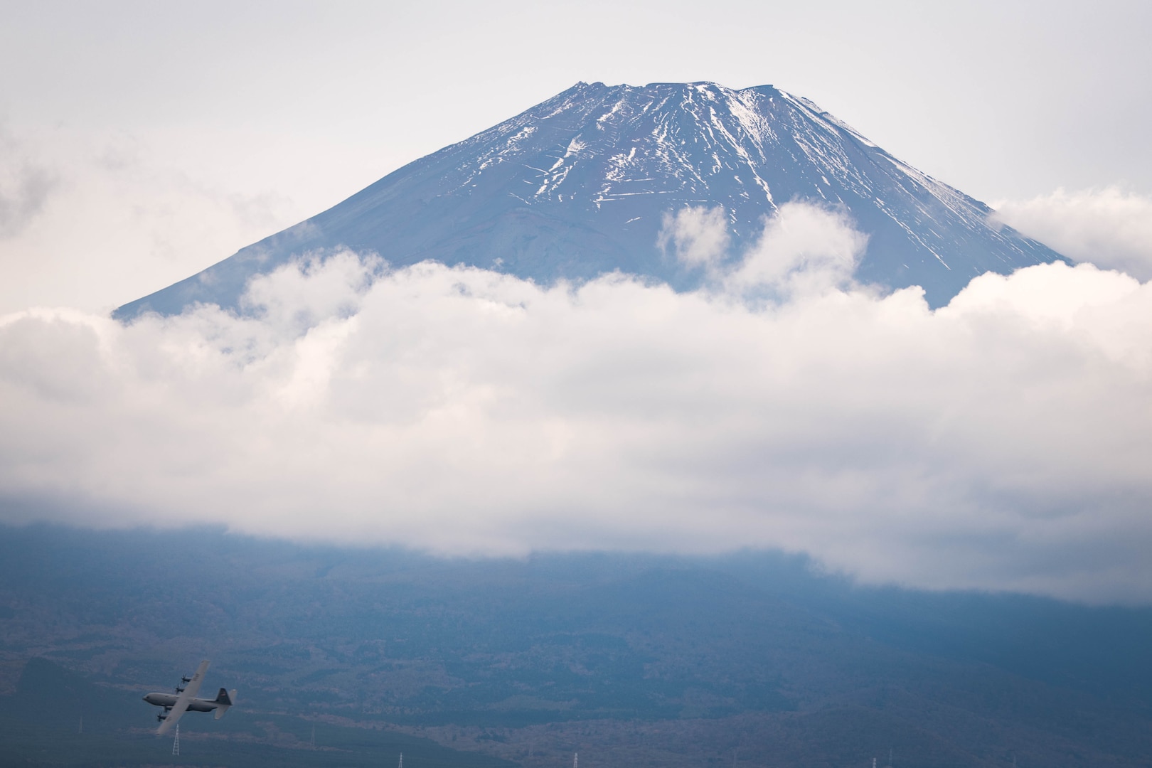 A C-130J Super Hercules assigned to the 36th Airlift Squadron passes over a drop zone near Mt. Fuji following simulated supply crate launches during Exercise Beverly Morning 24-1 at Yokota Air Base, Japan, Oct. 25, 2023. The 36th AS routinely trains to ensure aircrew and airfield operations teams can perform in contingent environments. (U.S. Air Force Photo by Senior Airman Brooklyn Golightly)