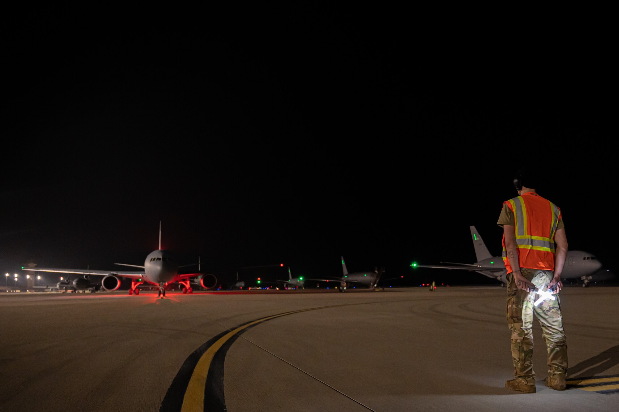 U.S. Air Force Senior Airman Lane Hilderbrand, 605th Aircraft Maintenance Squadron flying crew chief, marshals five KC-46A Pegasus’ during the Neptune Series at Travis Air Force Base, Calif., Oct. 24, 2023. This joint air interoperability exercise is the first-ever certification event for the KC-46A Pegasus tankers assigned to Joint Base McGuire-Dix-Lakehurst, N.J. (U.S. Air Force photo by Airman 1st Class Simonne Barker)